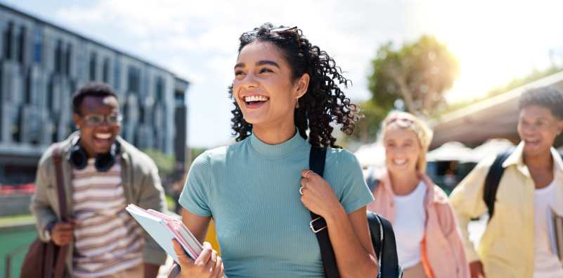 Group of happy university students walking outdoors on campus
