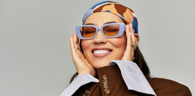 A woman wearing blue sunglasses with neutral-toned lenses
