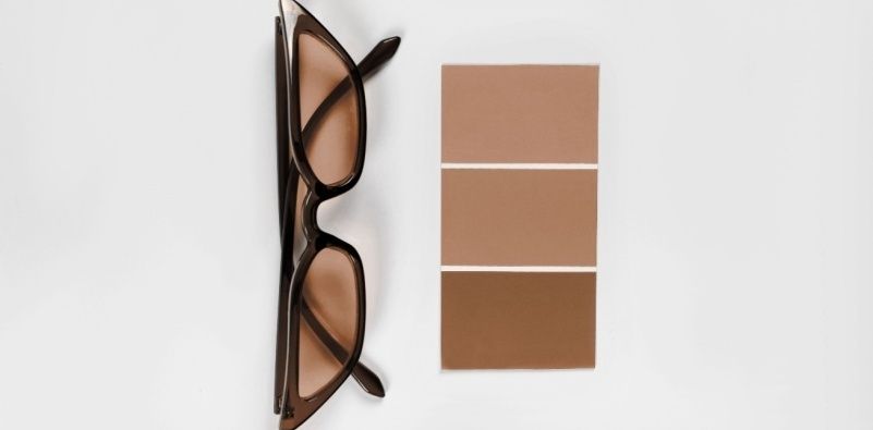 A pair of car eye sunglasses in the shade Mocha Mousse with other brown tone colour examples in squares next to it