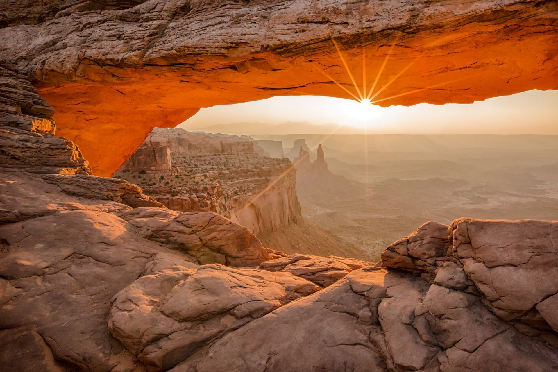 Mesa Arch in Canyonlands National Park with the sun rising just under it.