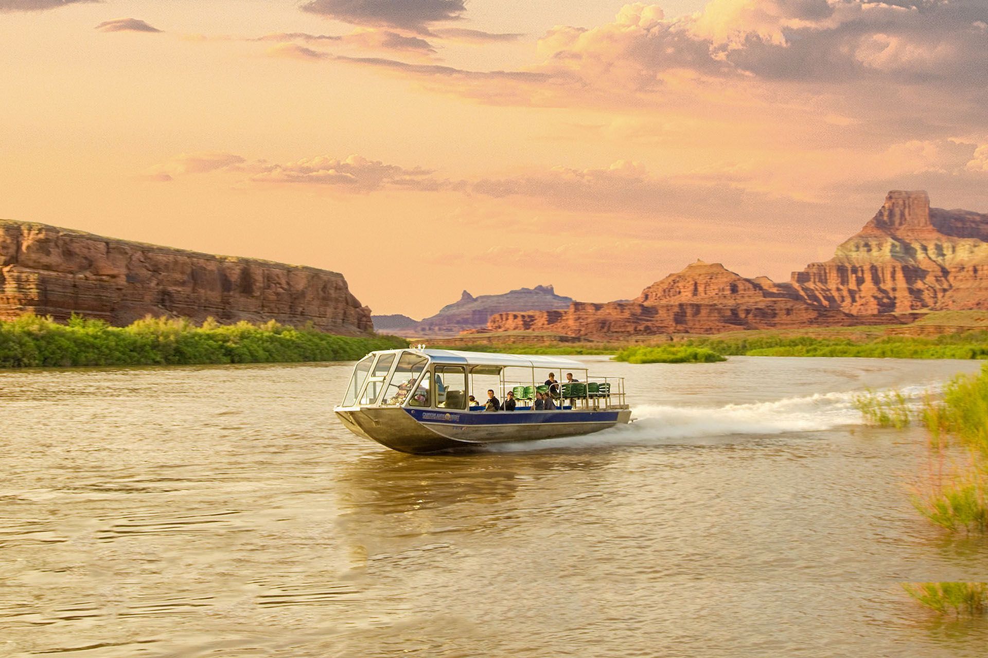 A boat is floating on a river with mountains in the background.
