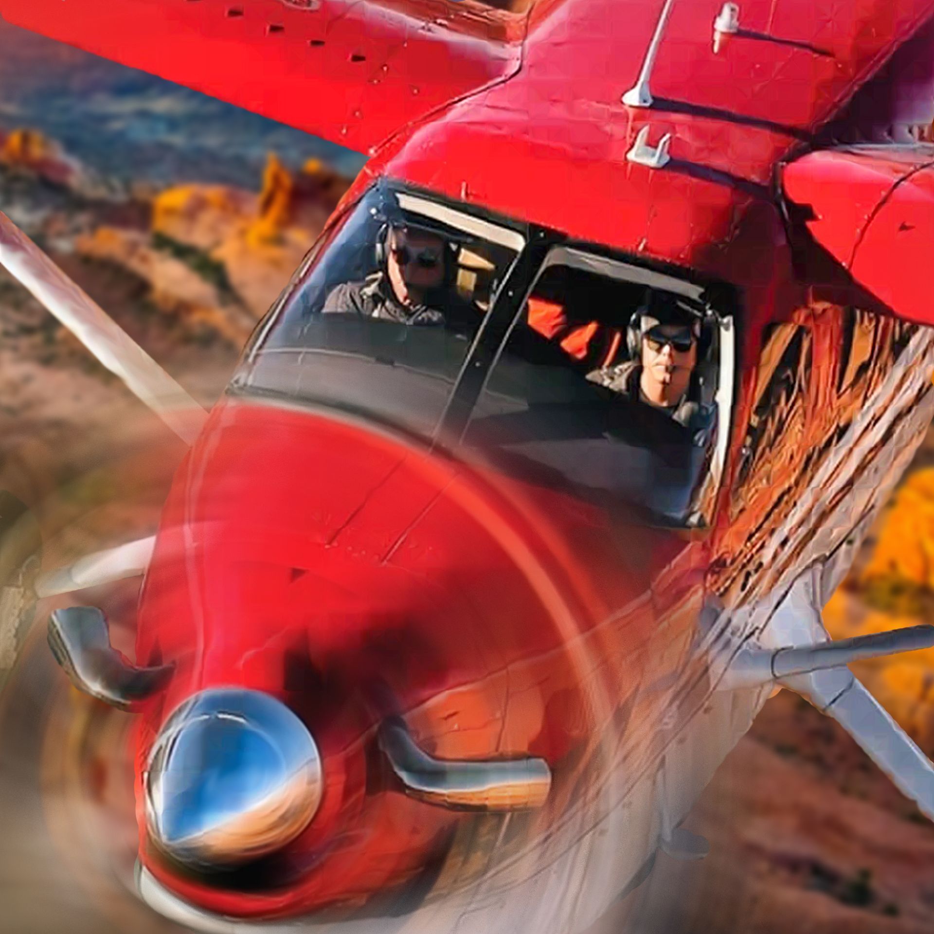 Red airplane in flight; two pilots in cockpit, mountains in background.
