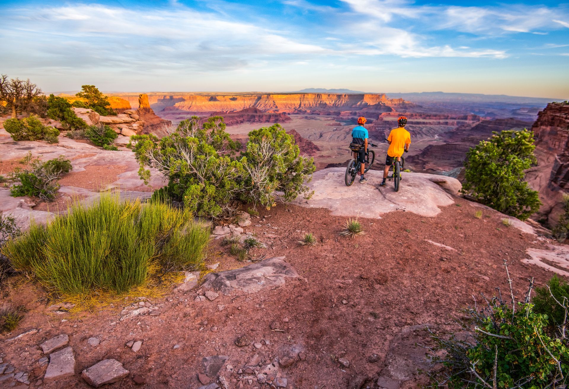 A man and a woman are riding bikes on a dirt road.