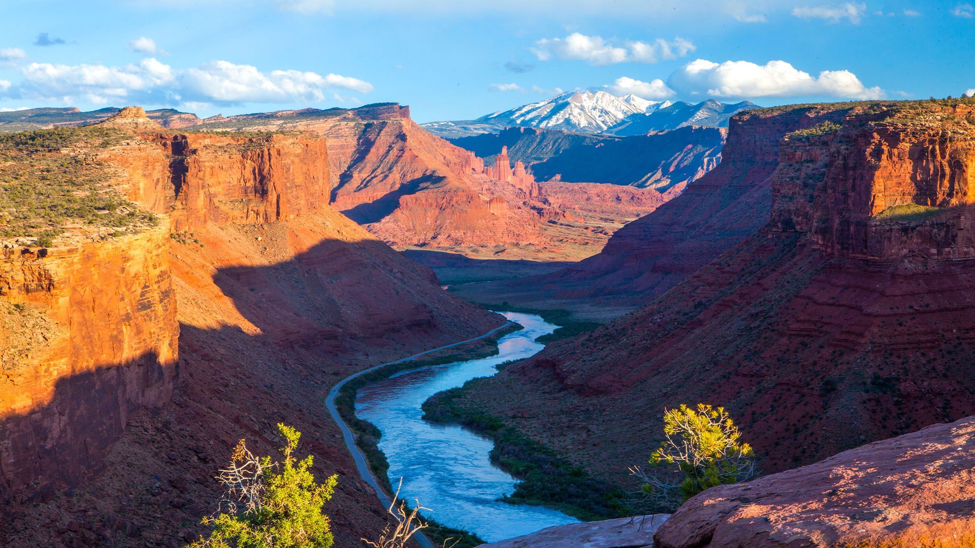 An aerial view of a river flowing through a canyon where campgrounds are located along the river's edge.