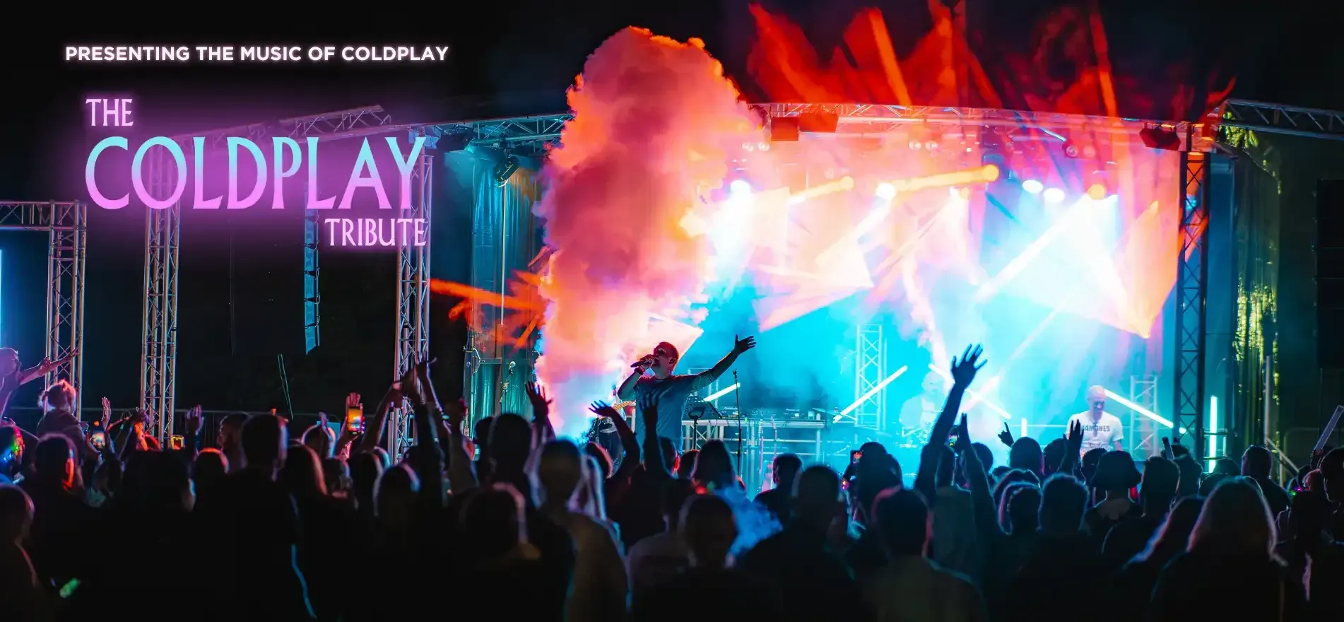 Coldplay concert with bright neon stage lights and a cheering crowd at night