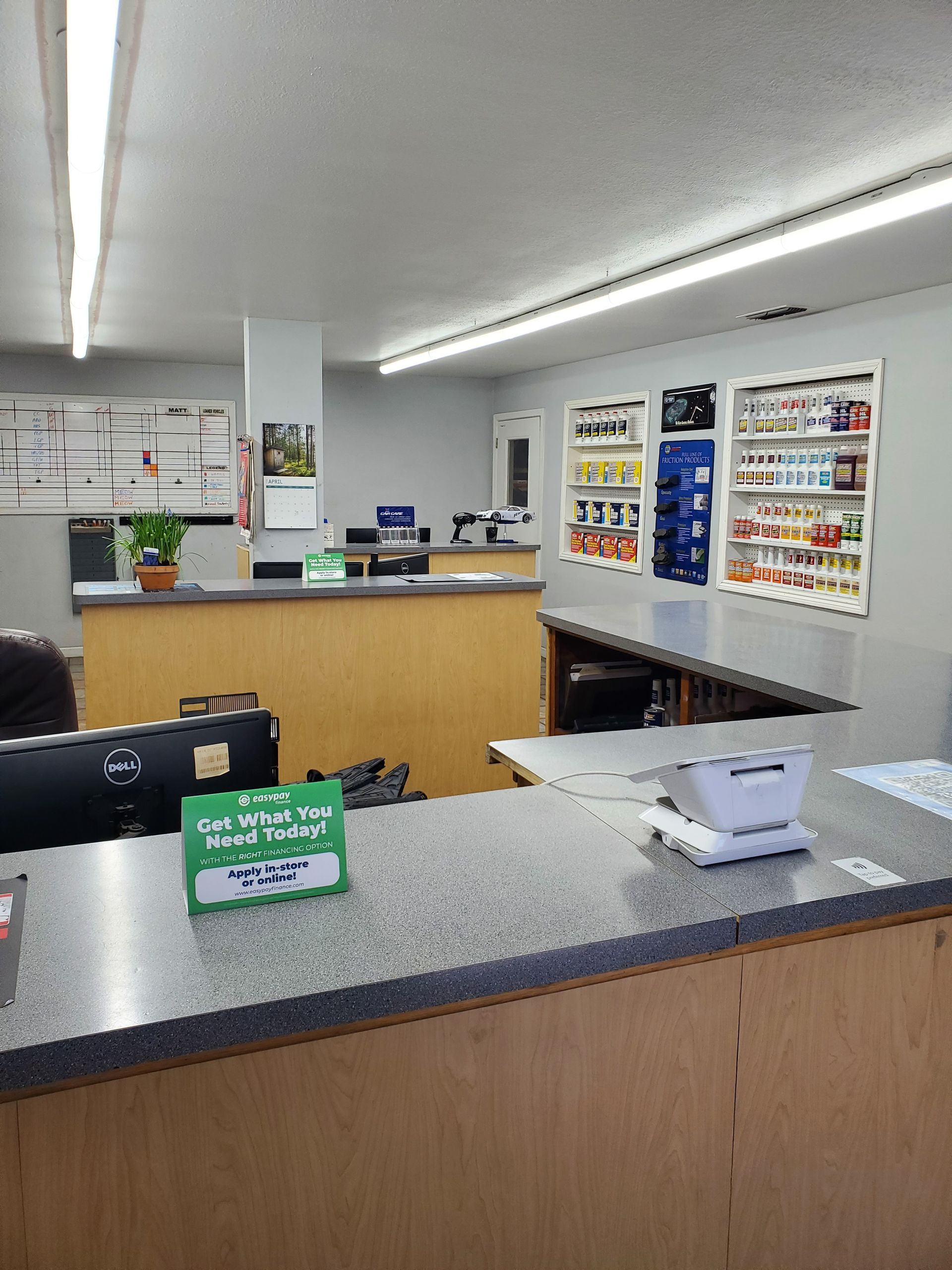 A store counter with displays of products and a cash register. Light-colored walls and ceiling. | Hal's Auto Care