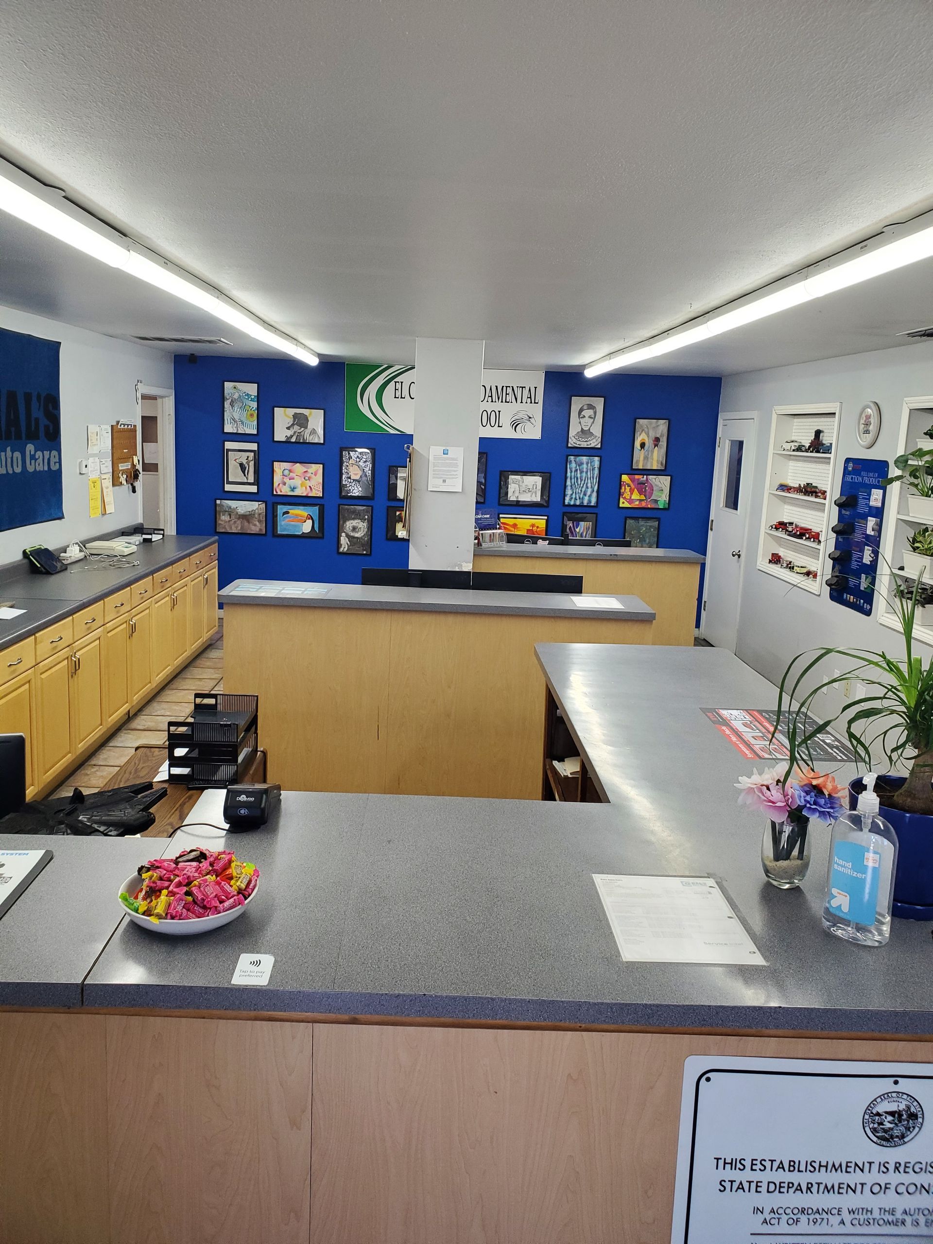 Interior of a small shop with blue and tan counters, framed photos on blue walls. | Hal's Auto Care