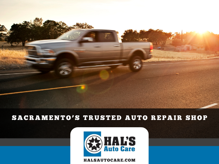Silver pickup truck driving on road at sunset, HAL's Auto Care logo. Sacramento's trusted auto repair shop.