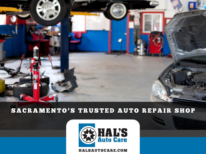 Auto repair shop interior with car on lift, open-hooded car in foreground.