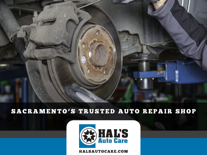 Mechanic working on car brakes in a repair shop with
