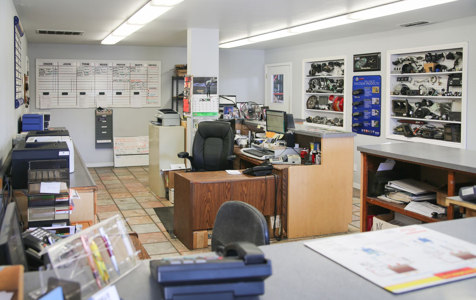 Interior of a mechanic shop office, with a desk, display of parts, and various equipment visible. | Hal's Auto Care