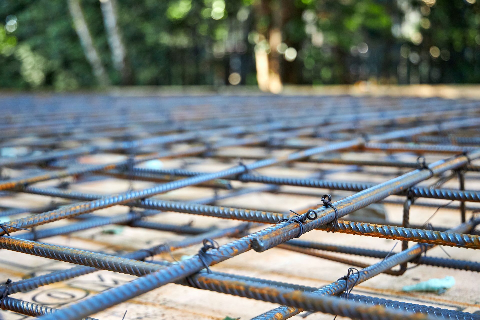 Reinforced steel rebar grid laid for a concrete foundation, outdoors.