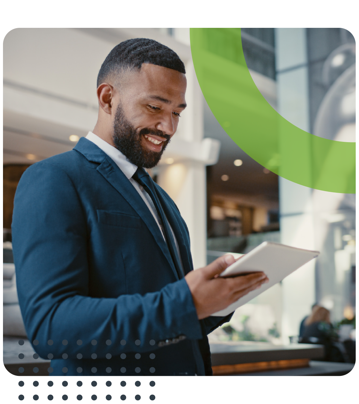A man in a suit and tie is looking at a tablet.