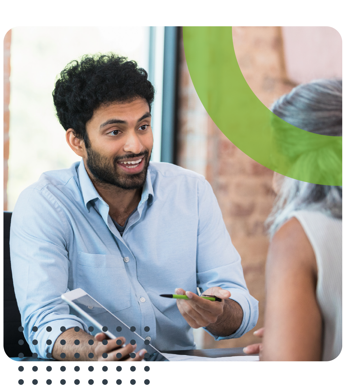A man is sitting at a table talking to a woman.