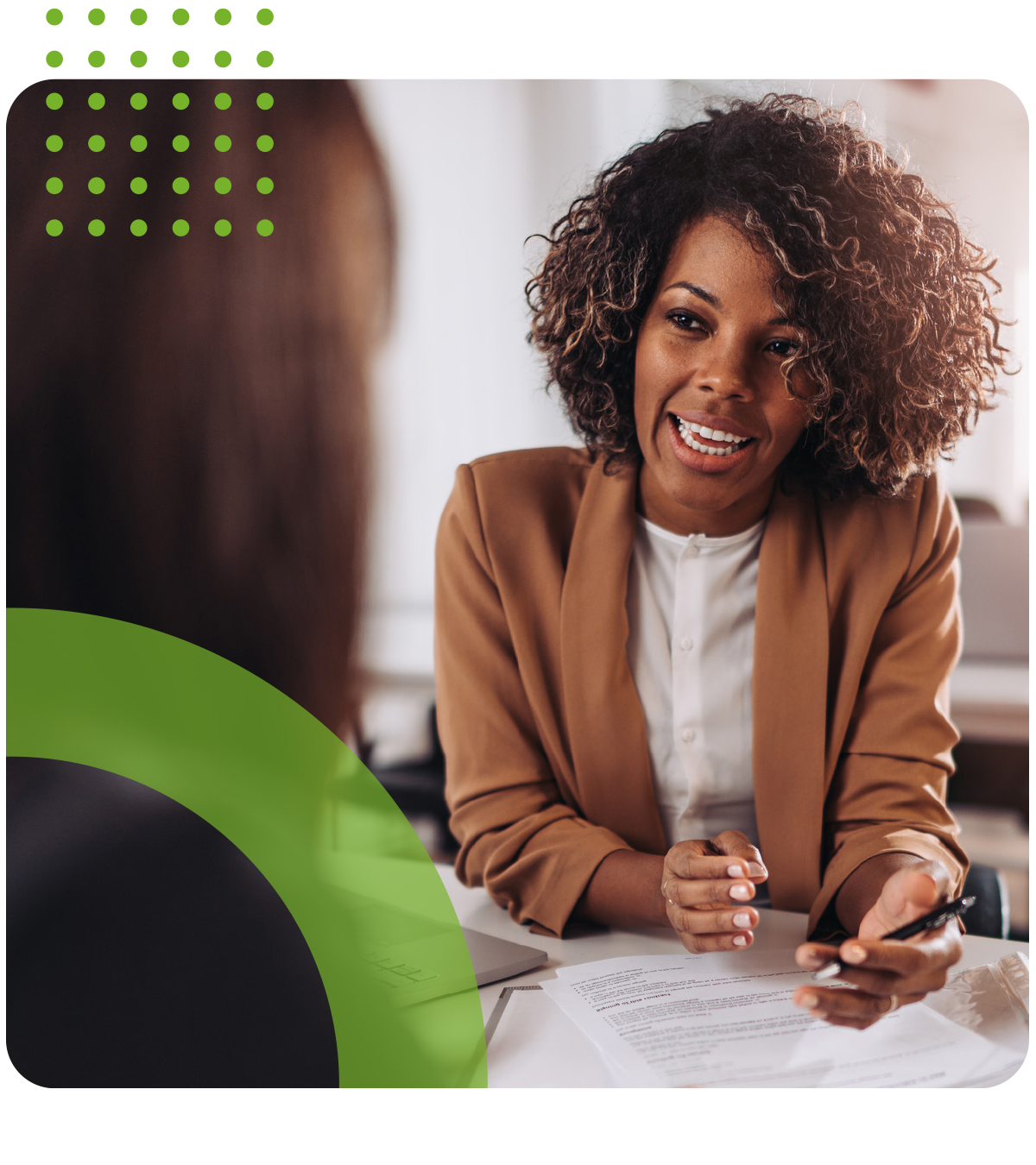 A woman is sitting at a table talking to another woman.