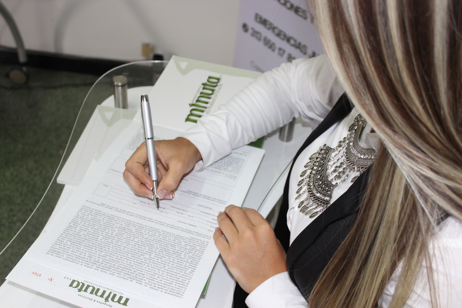 Una mujer está sentada en un escritorio frente a una computadora.