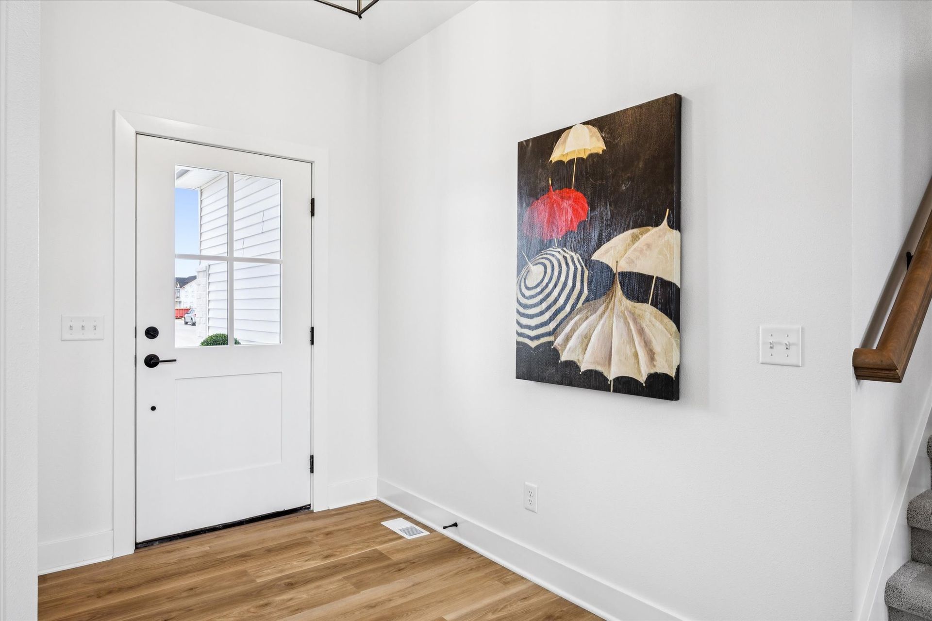 A hallway with a painting of umbrellas on the wall.