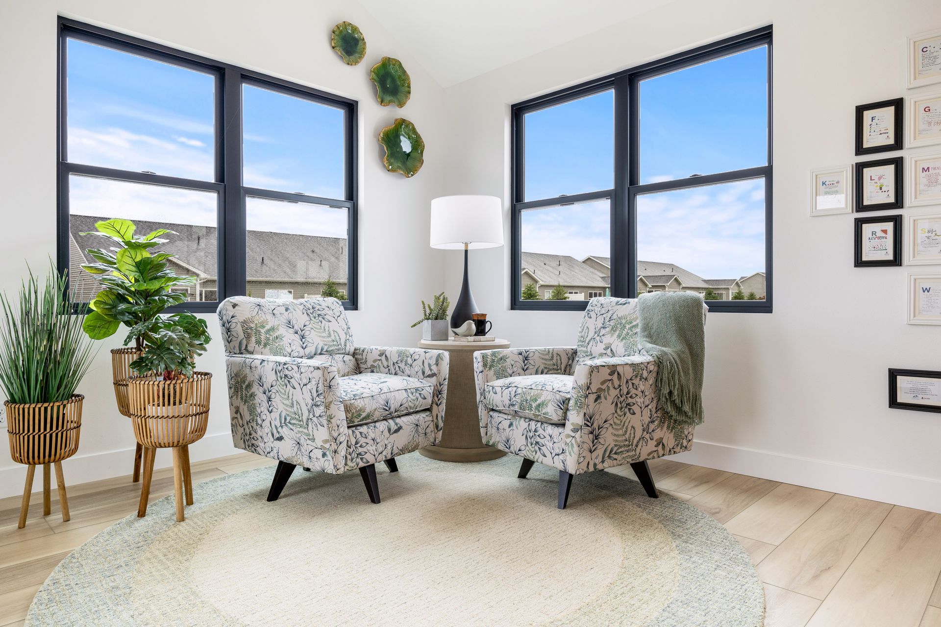 A living room with two chairs , a table , and a lamp.