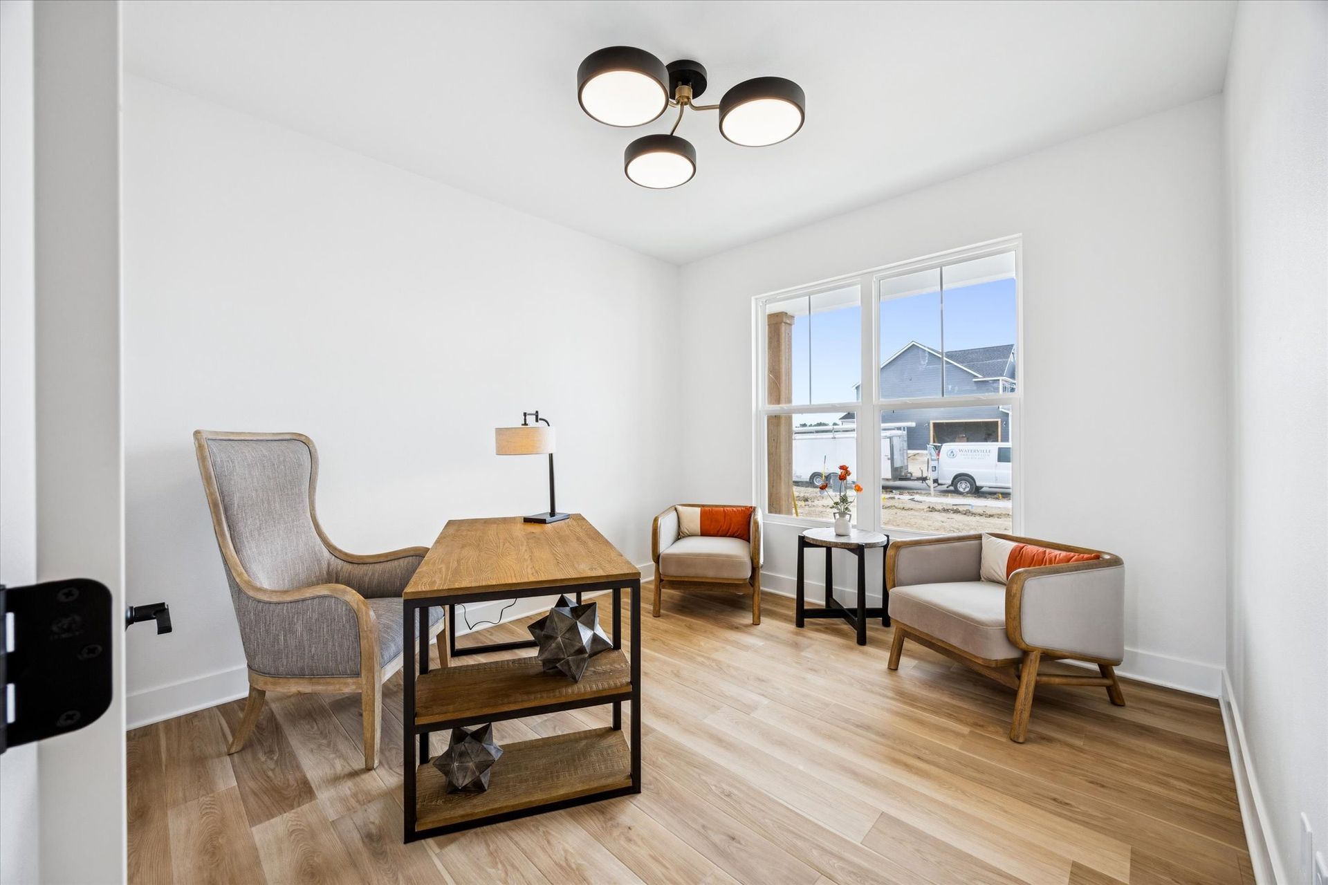A living room with two chairs , a table , and a window.