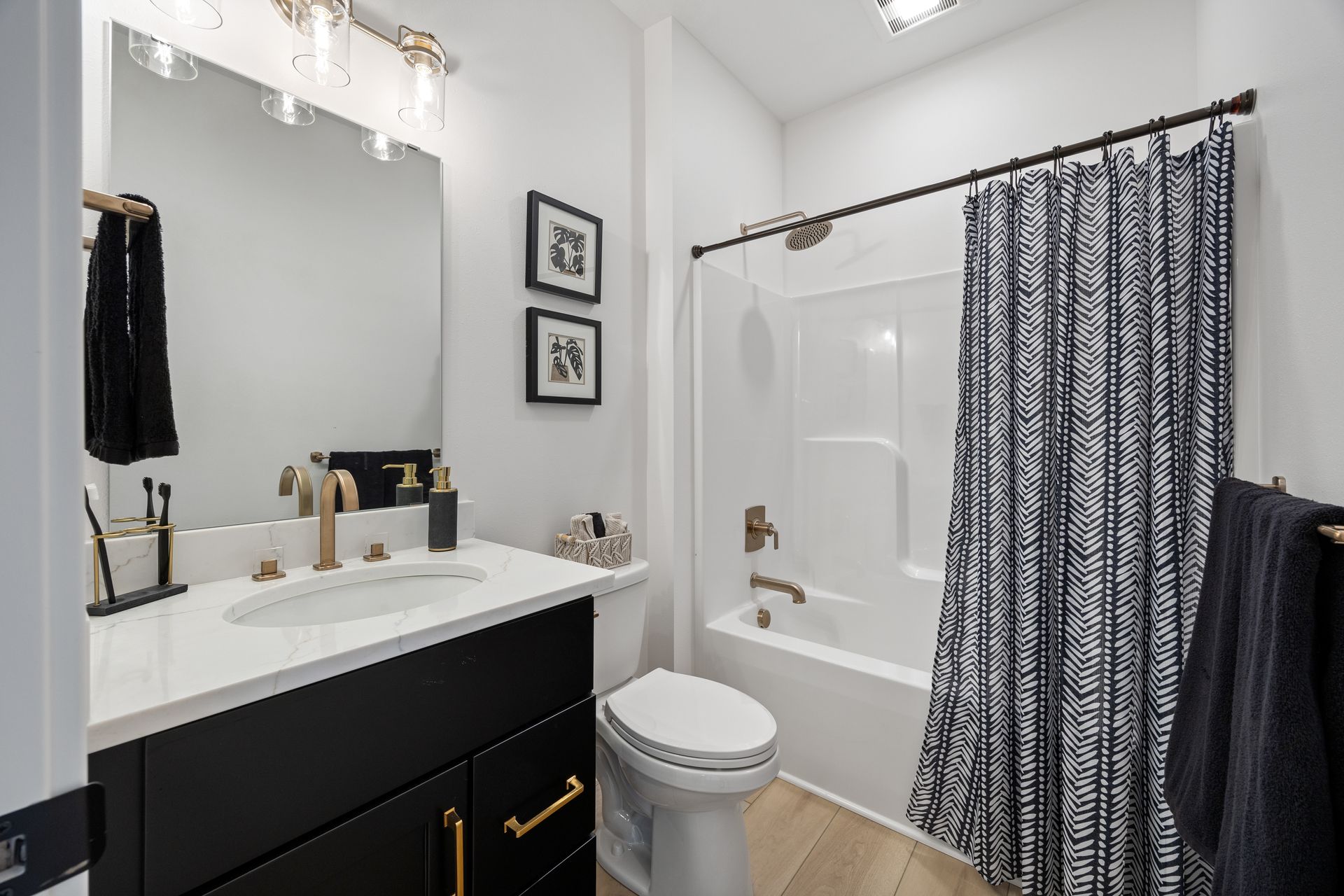 A bathroom with a sink , toilet , bathtub and shower curtain.