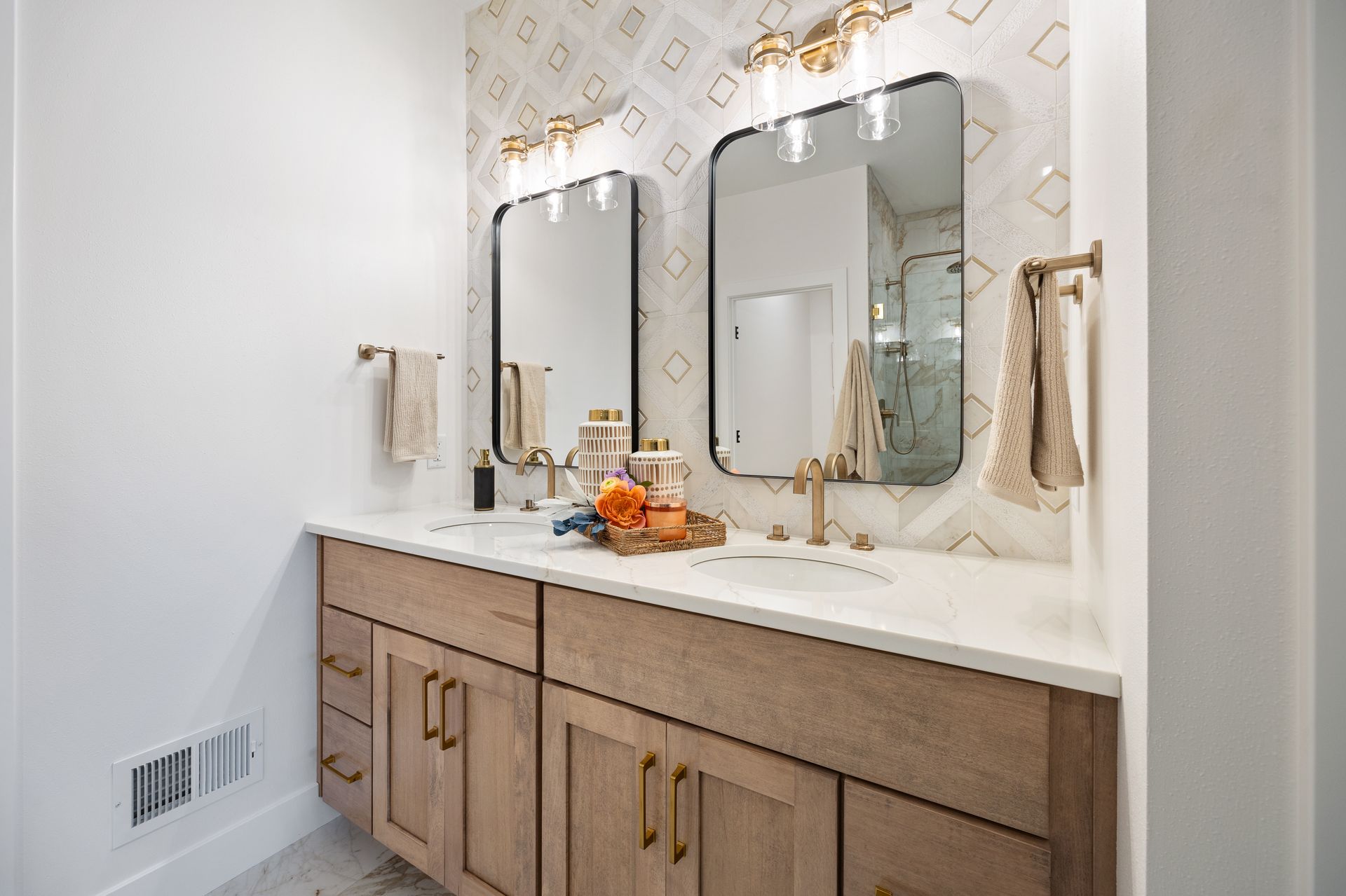 A bathroom with two sinks and two mirrors.