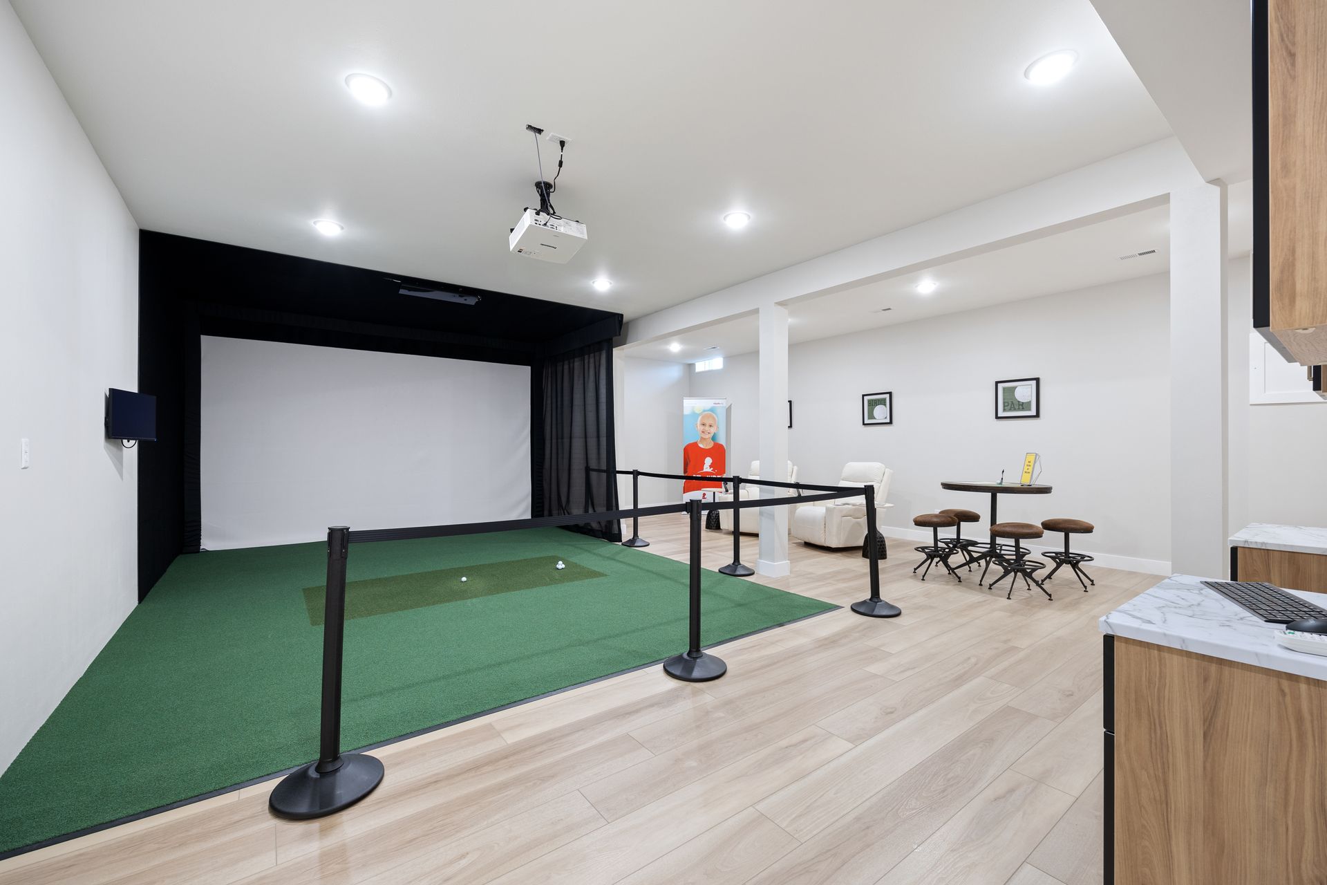 There is a golf simulator in the middle of the room.