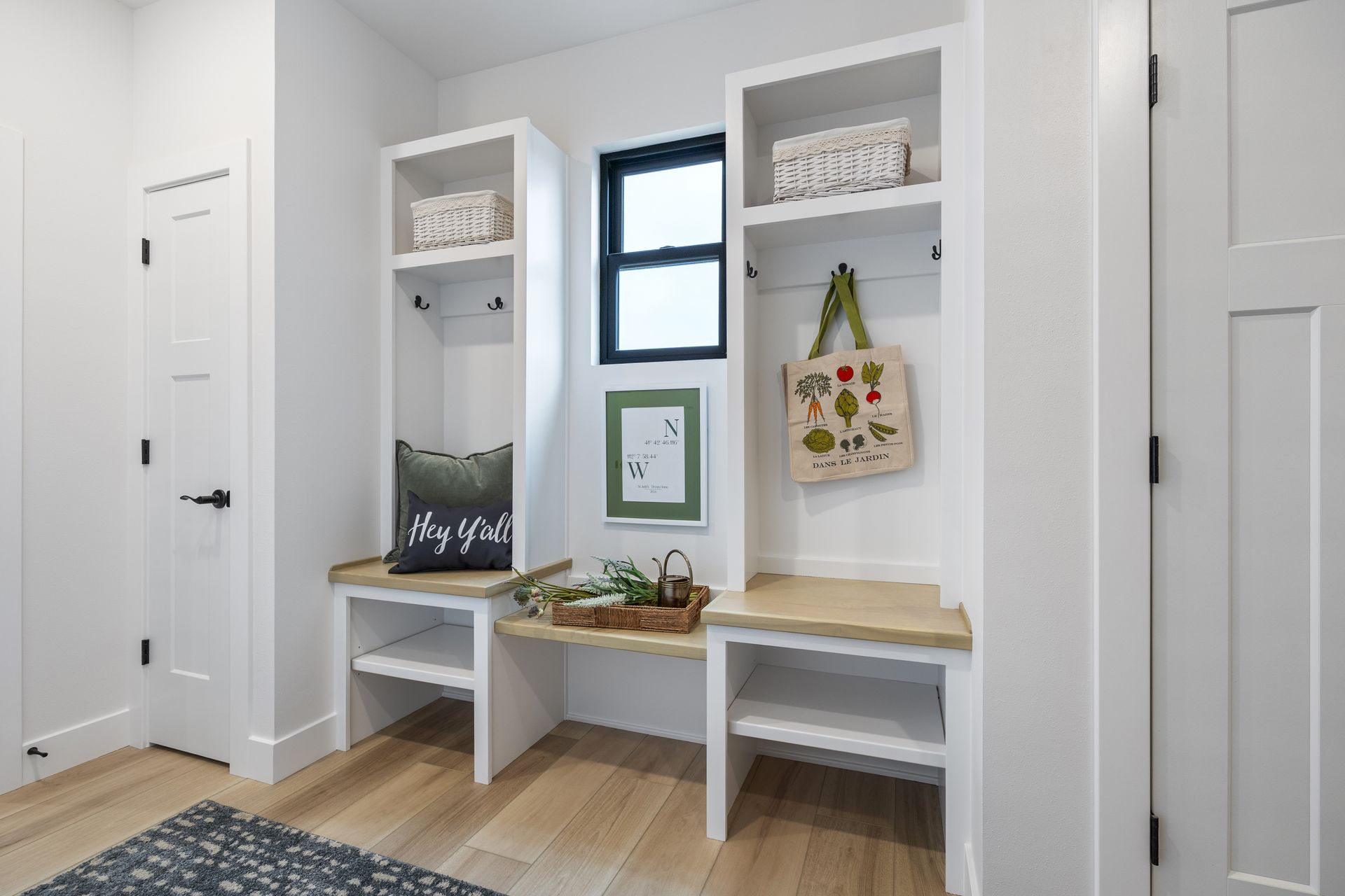 A hallway with a bench , shelves , and a window.