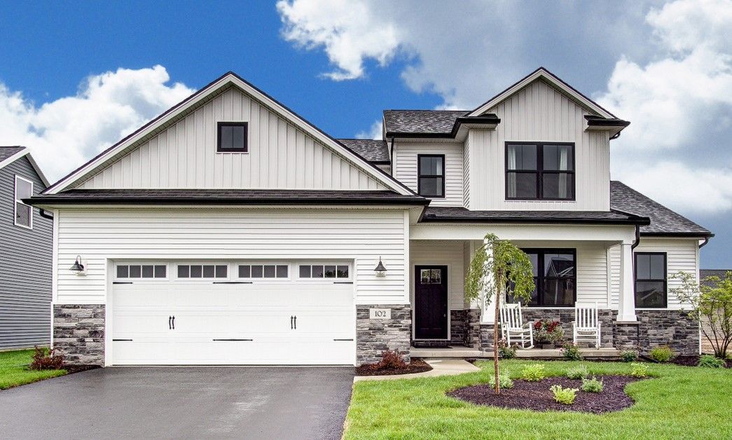 A large white house with a large garage and a porch.