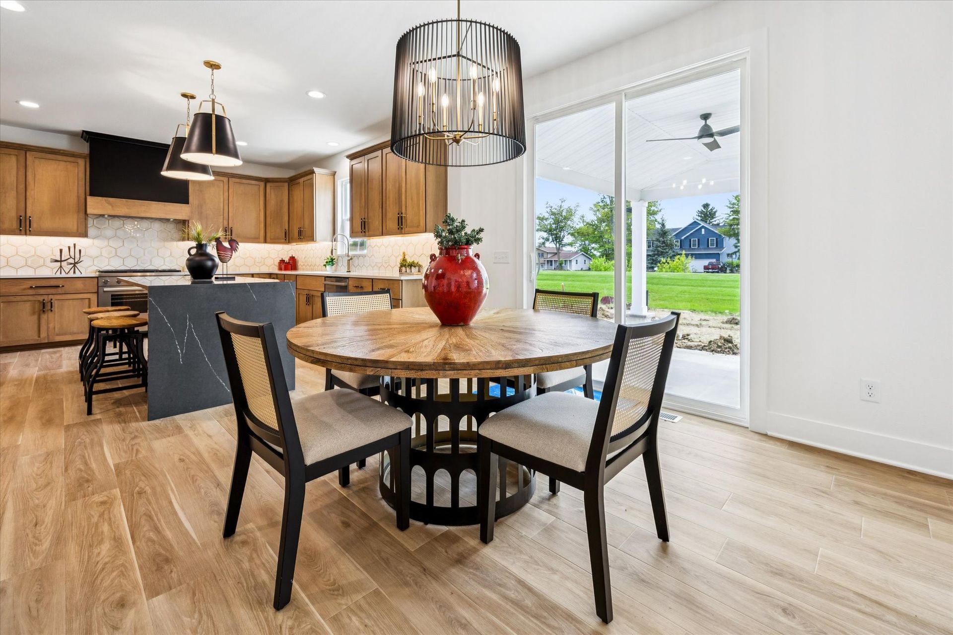 A dining room with a round table and chairs and a chandelier.