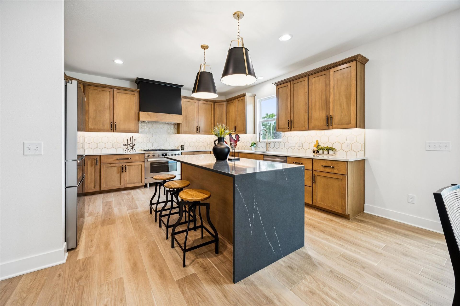 A kitchen with wooden cabinets and a large island in the middle.