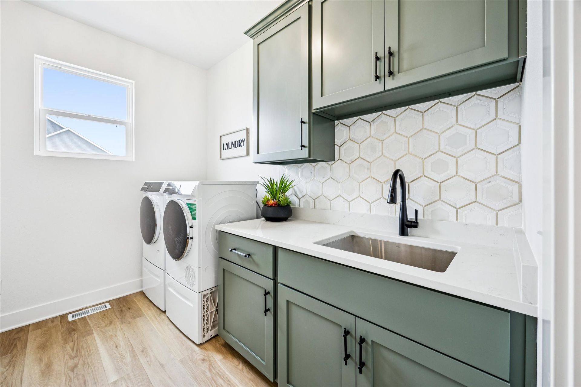 A laundry room with a washer and dryer and a sink.