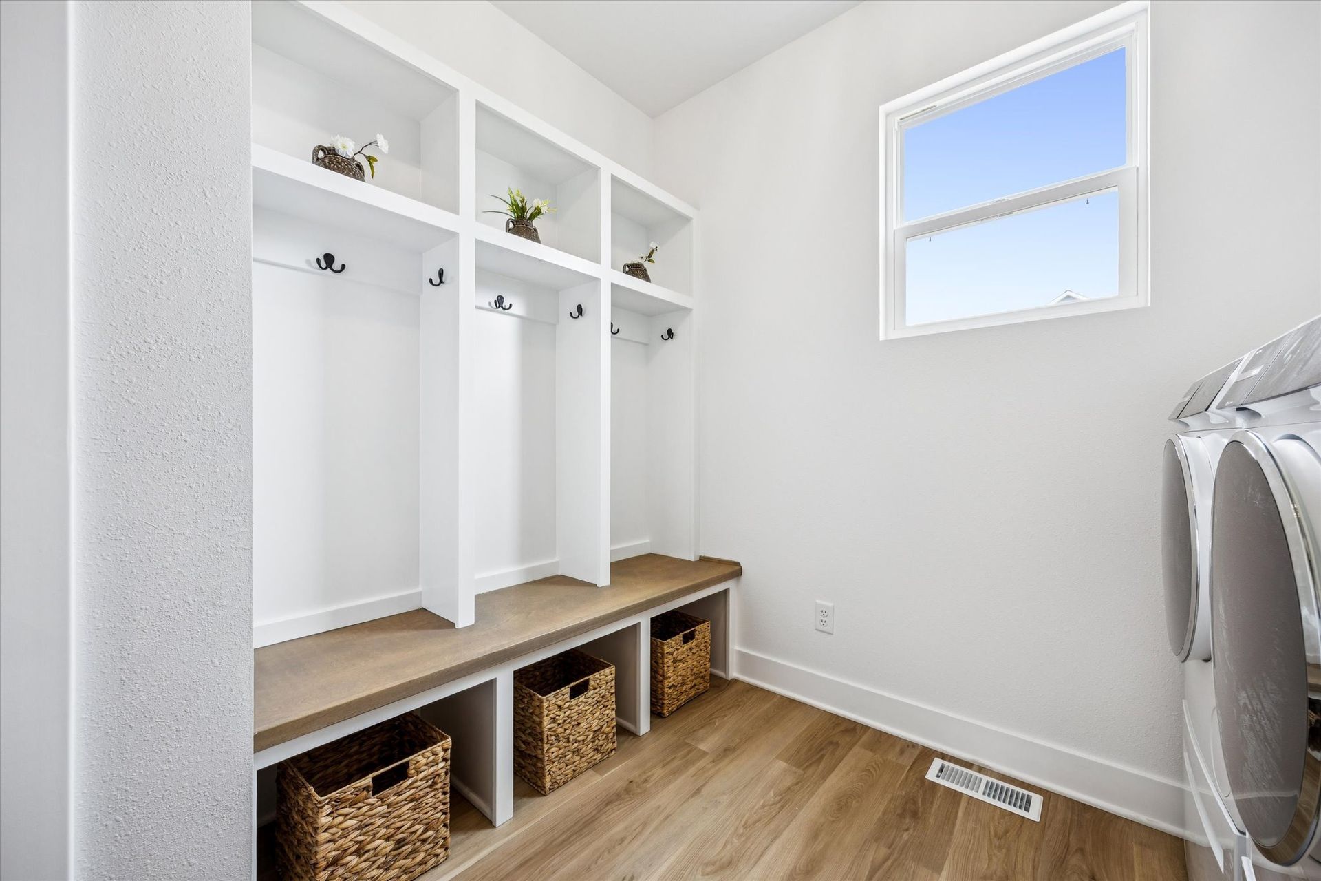 A laundry room with a washer and dryer and a window.