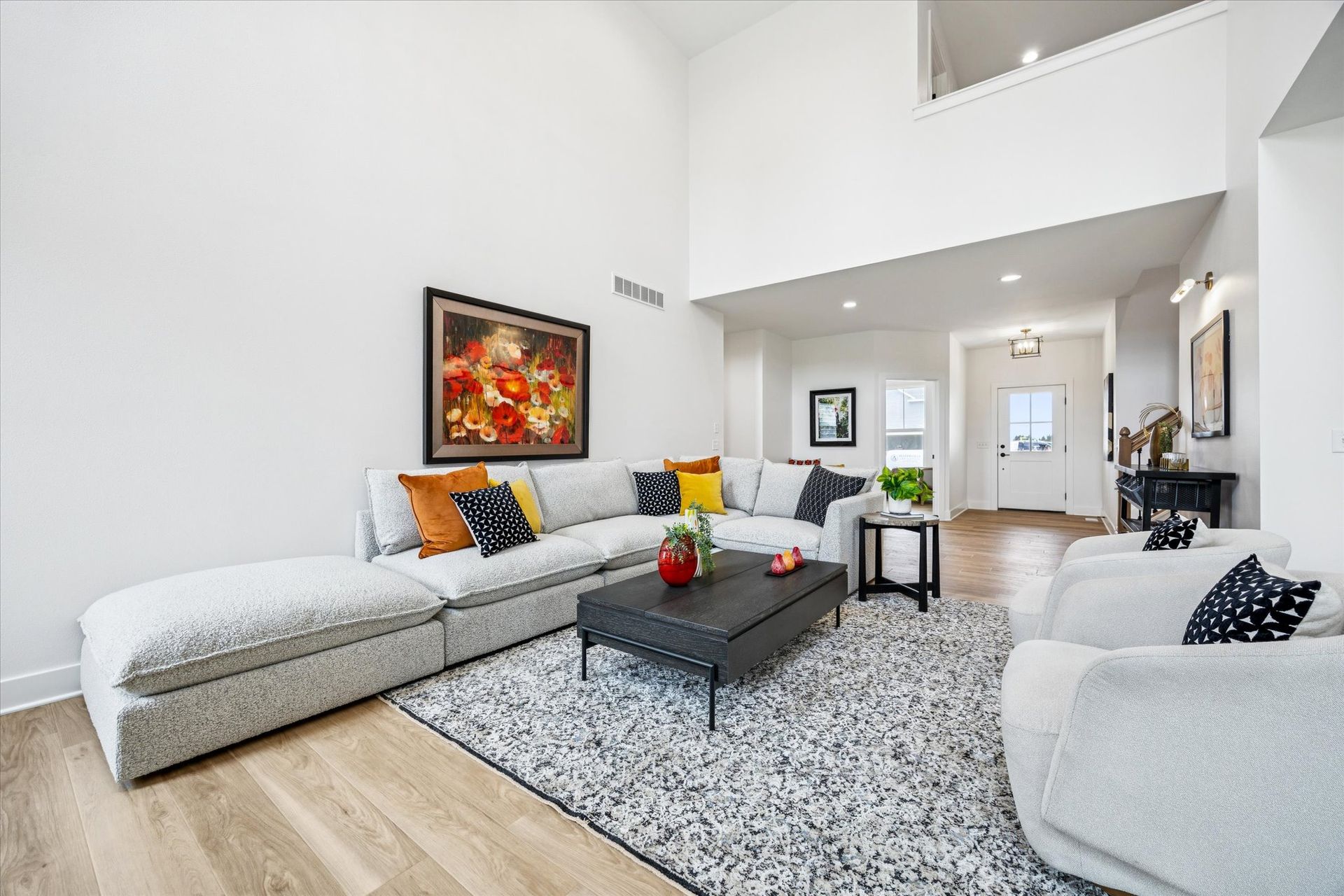 A living room with a couch , chairs , coffee table and rug.