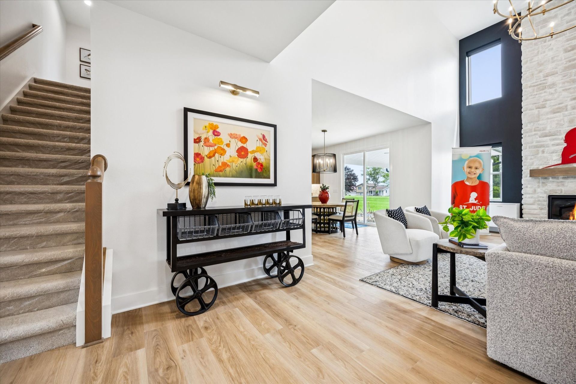 A living room with hardwood floors and a staircase leading up to the second floor.