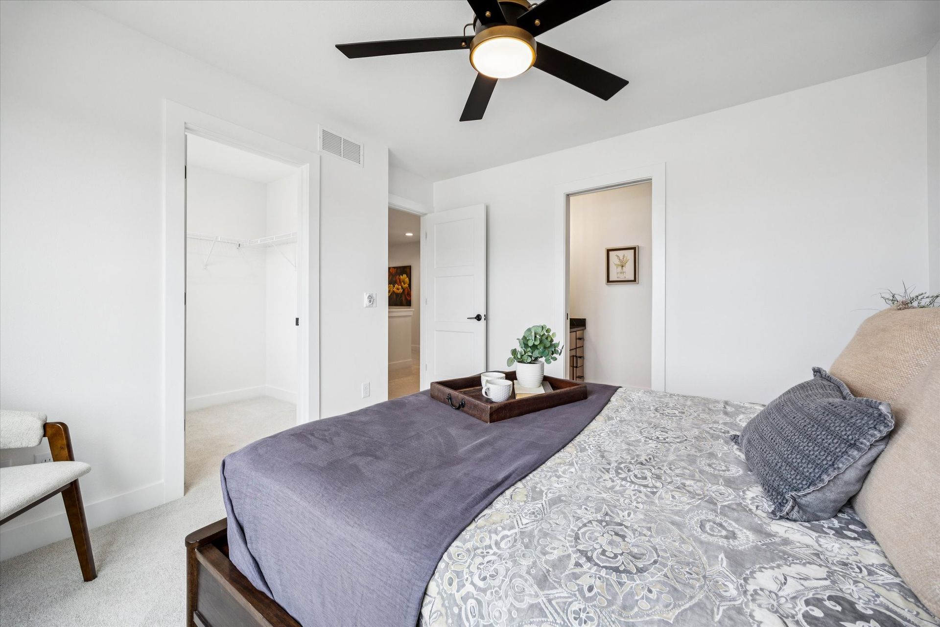 A bedroom with a bed and a ceiling fan.