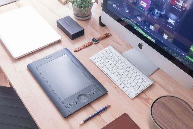 Un ordinateur Apple est posé sur un bureau en bois
