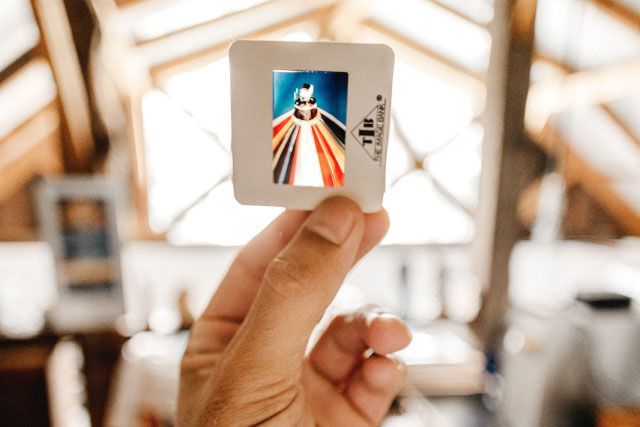 Une personne tient une diapositive avec une photo de Jésus dessus.