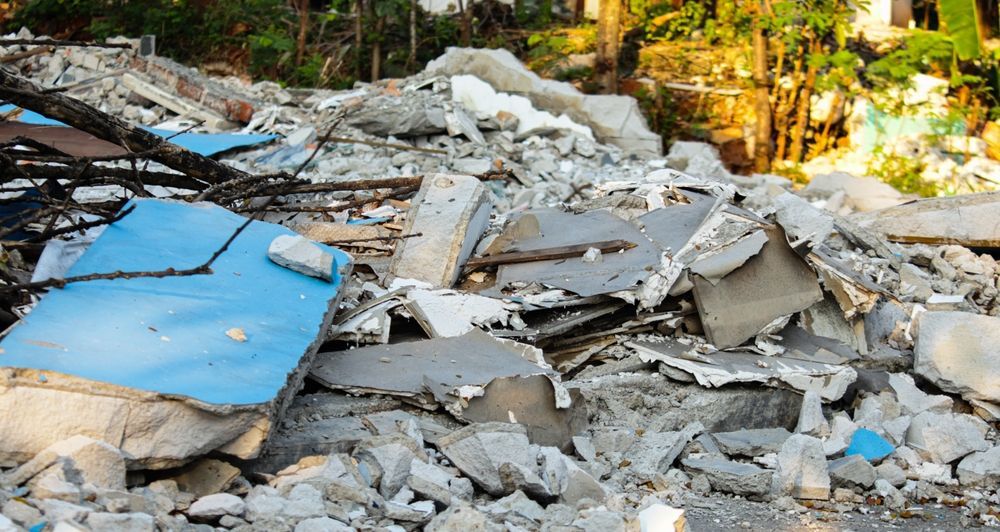 Pile of rubble and debris, likely from a collapsed building, with a blue object visible.