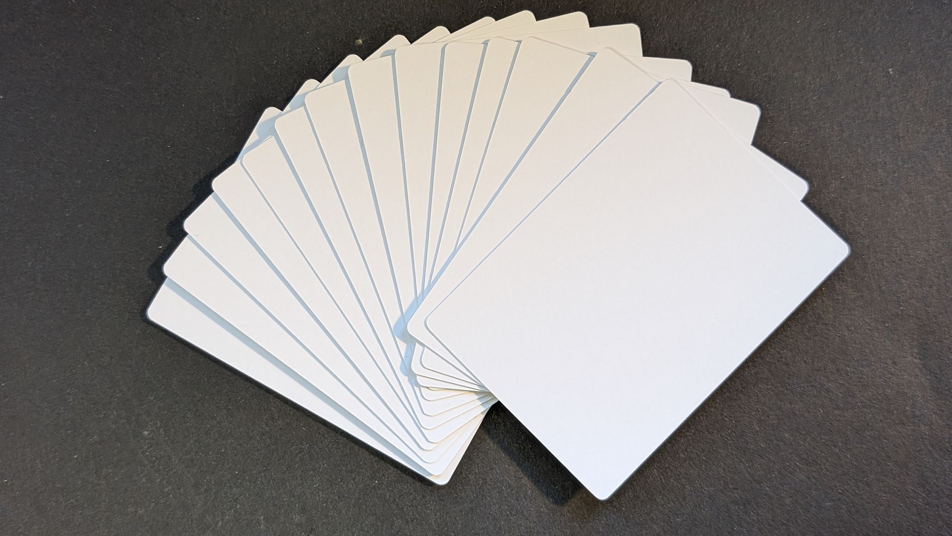 blank white cards splayed on a black background