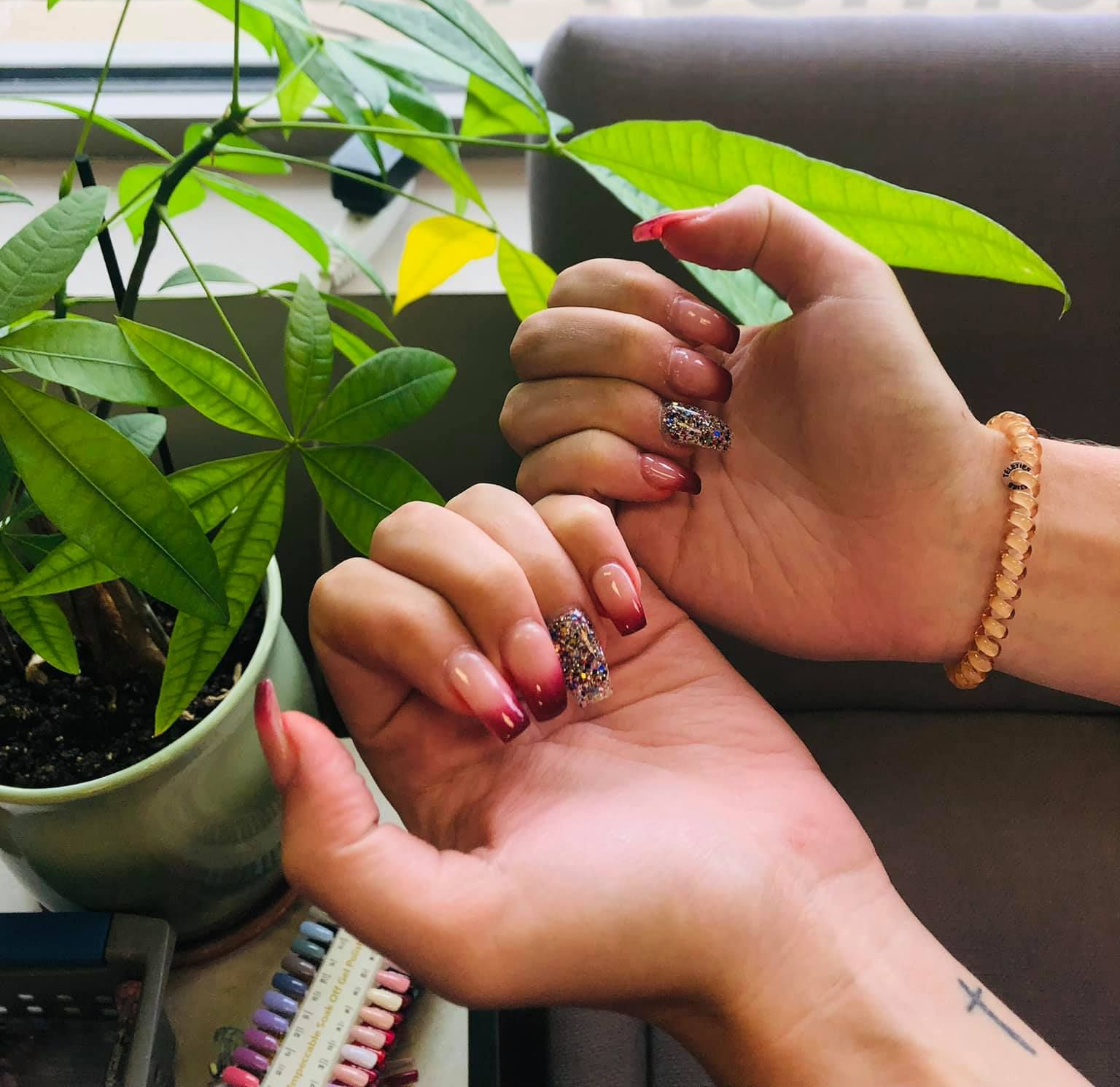 A close up of a woman 's feet and hands with pink nails.