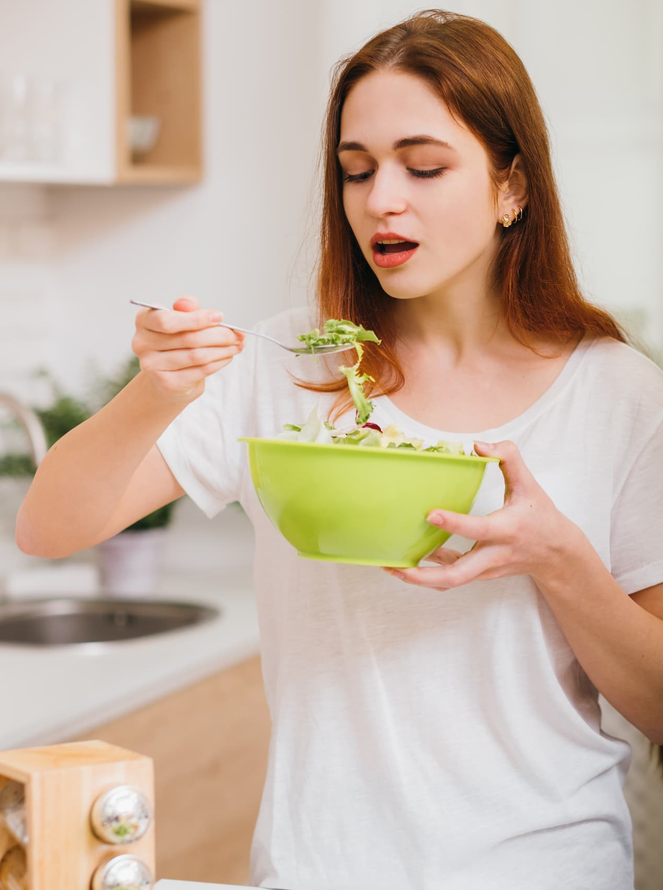 A woman eating a salad.