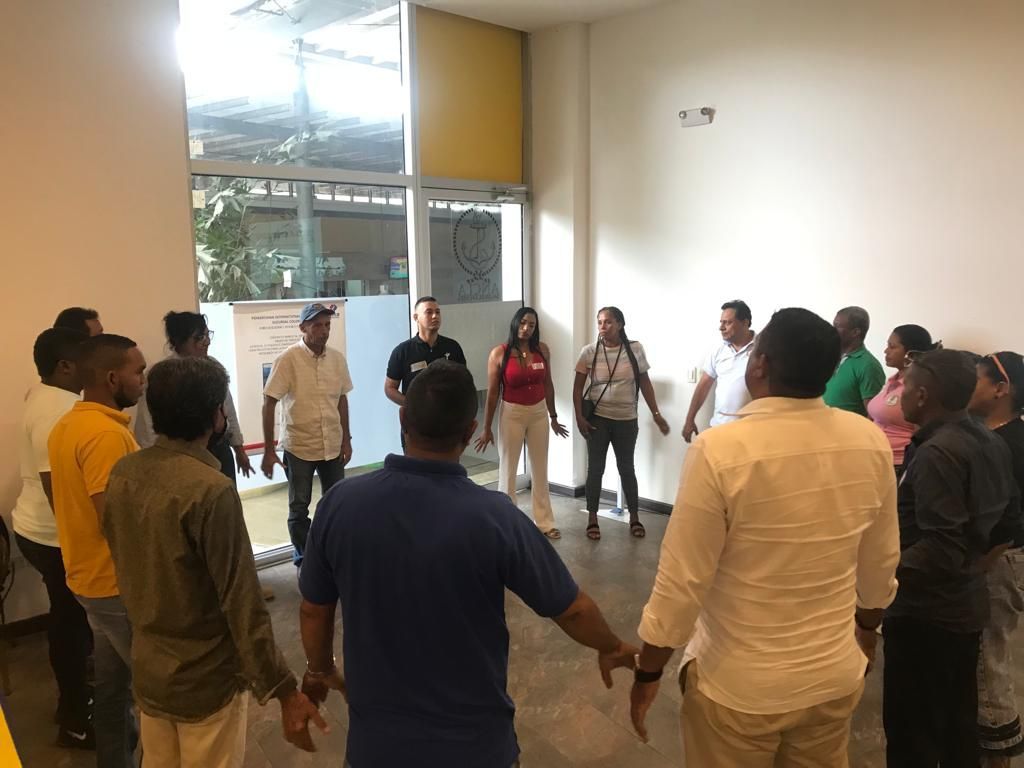 Un grupo de personas están de pie en un círculo tomadas de la mano.