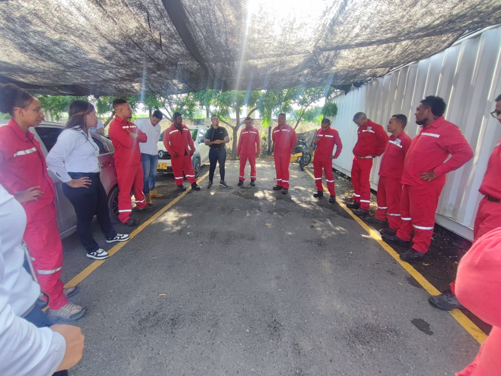 Un grupo de personas con monos rojos están de pie en un círculo.