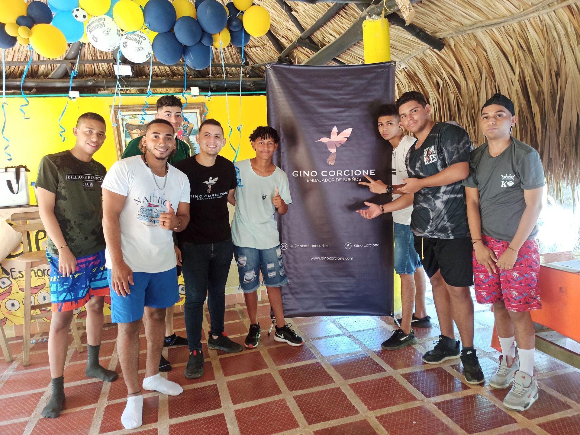 Un grupo de jóvenes posa para una fotografía en una habitación con globos colgando del techo.