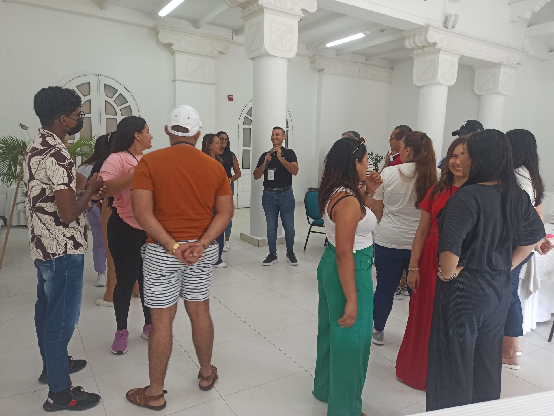 Un grupo de personas están de pie en una habitación hablando entre sí.