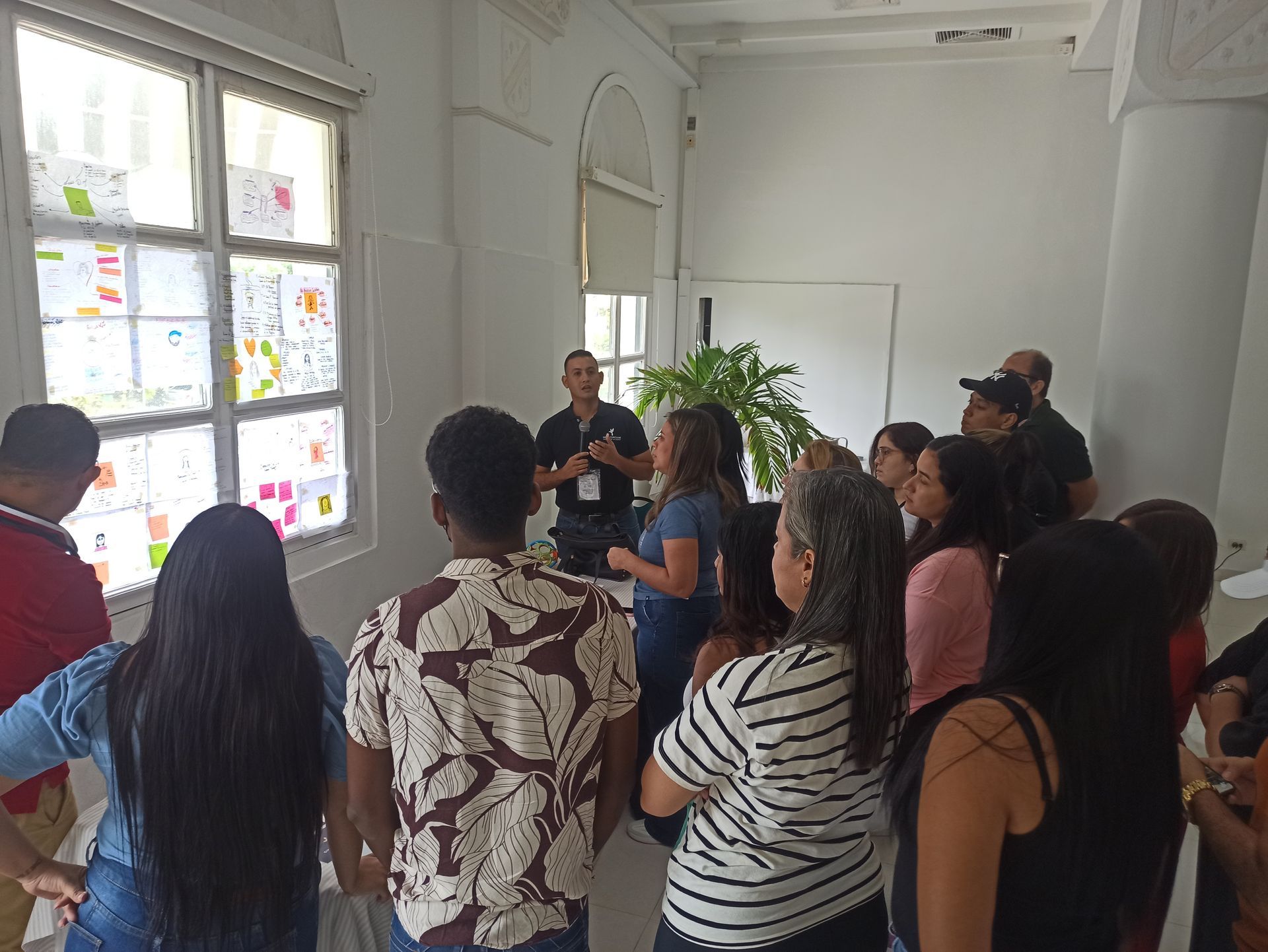 Un grupo de personas está de pie frente a una ventana en una habitación.