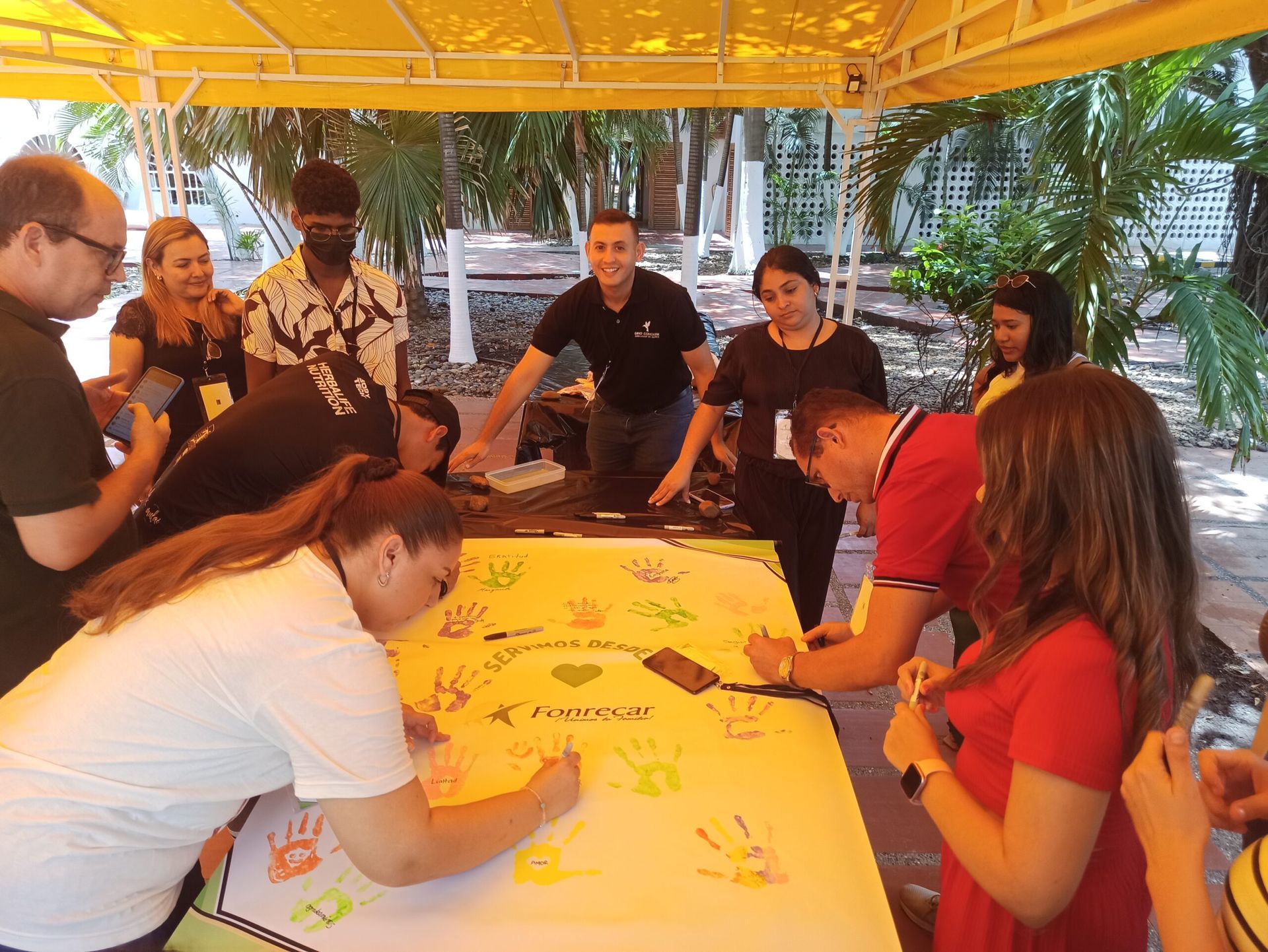 Un grupo de personas está escribiendo en un trozo grande de papel.