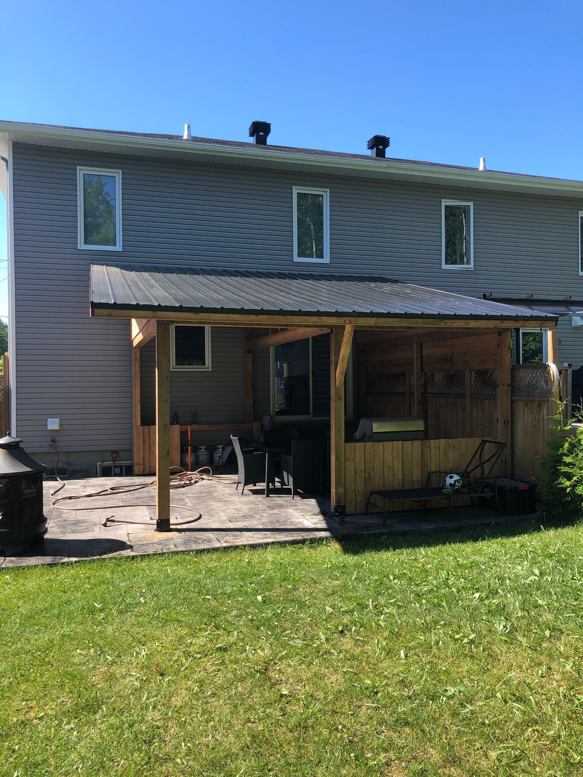 Une maison avec une terrasse couverte devant.