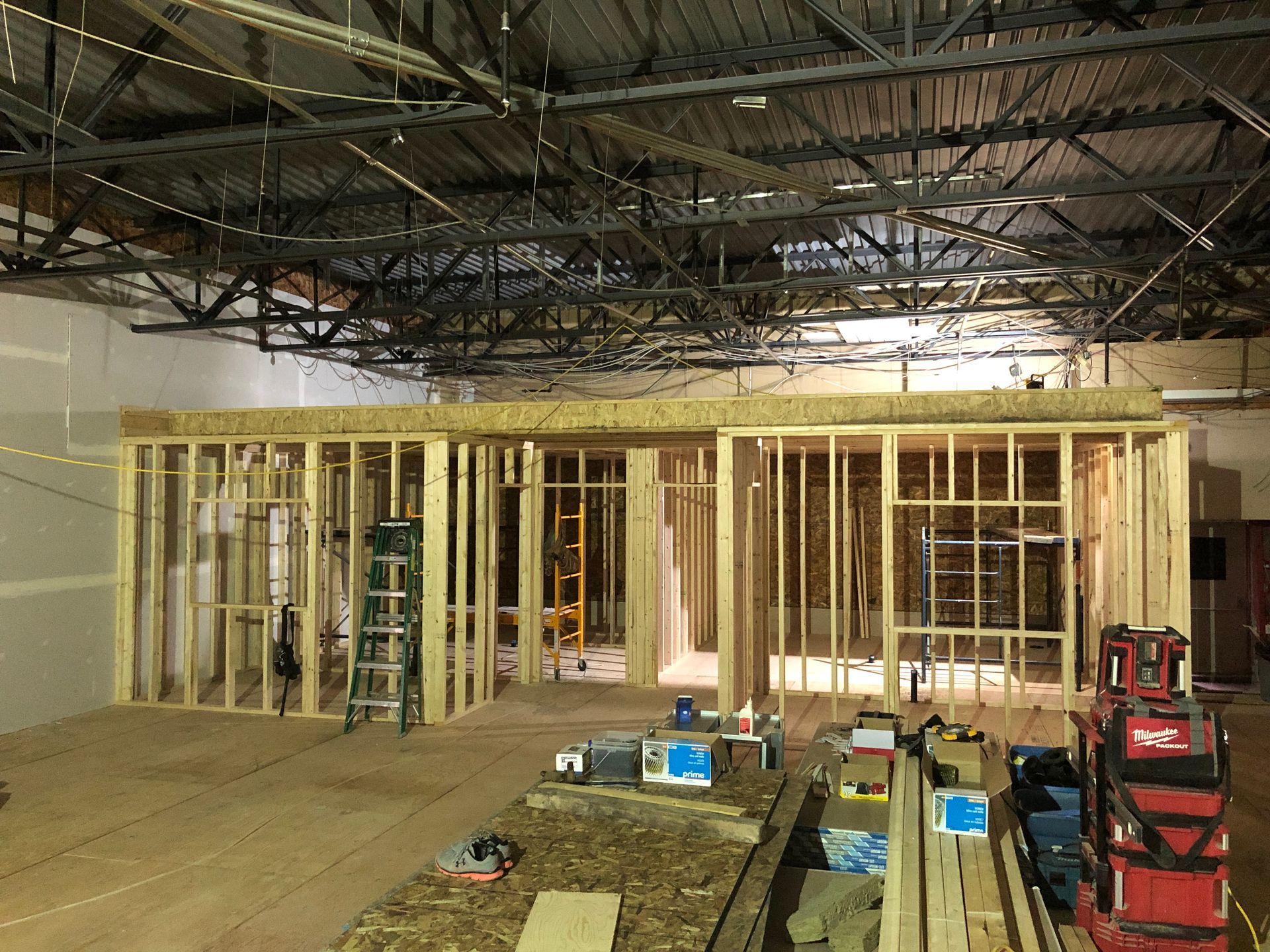 L'intérieur d'un bâtiment en construction avec des charpentes en bois.