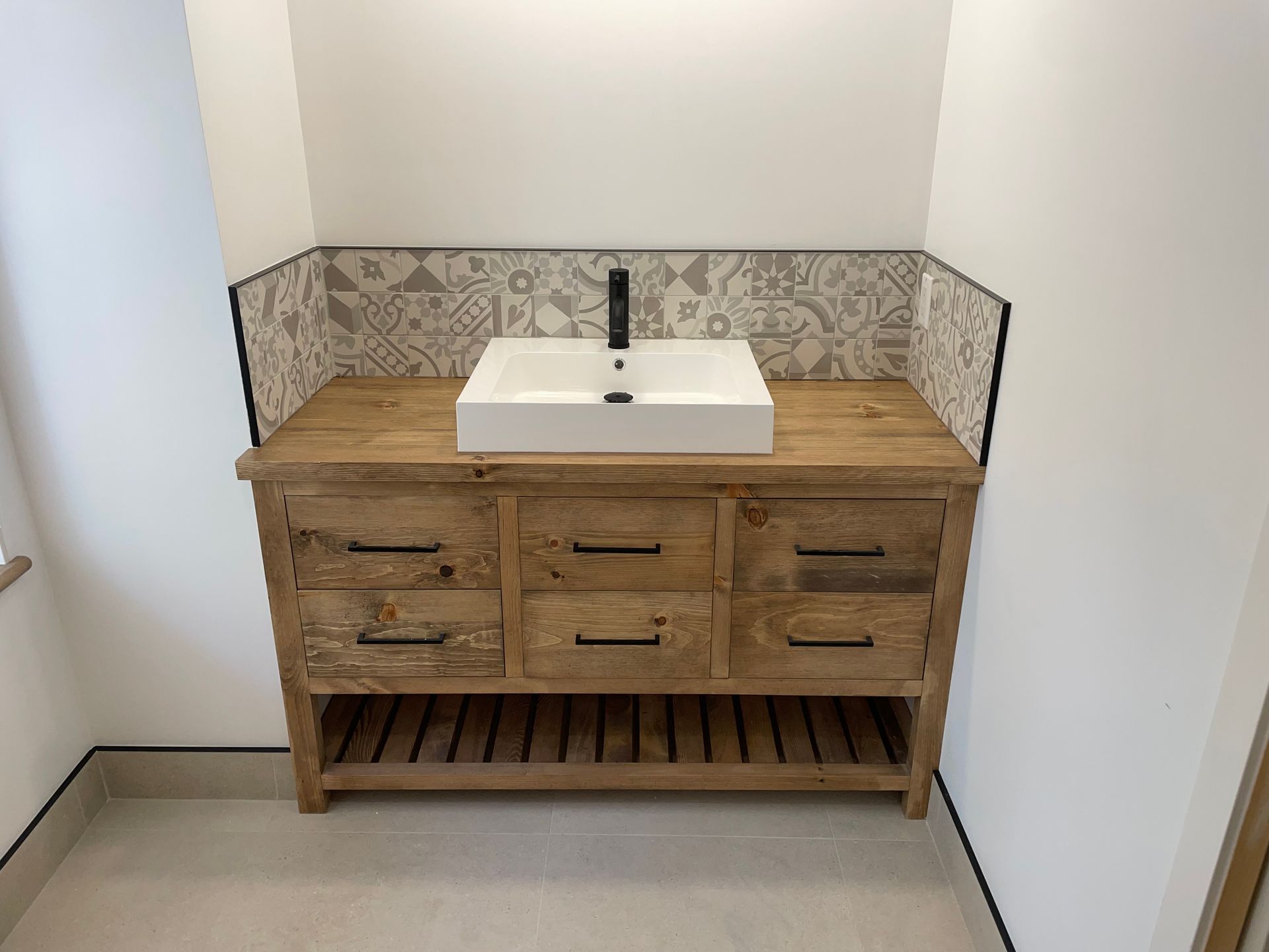 Une salle de bain avec une vasque en bois et un lavabo